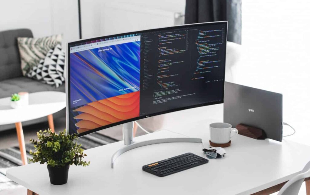 Ordenador sobre escritorio con código visible HTML y CSS en la pantalla