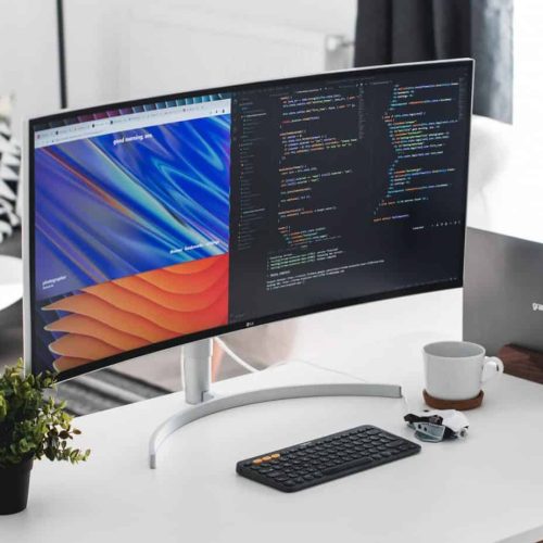 Ordenador sobre escritorio con código visible HTML y CSS en la pantalla