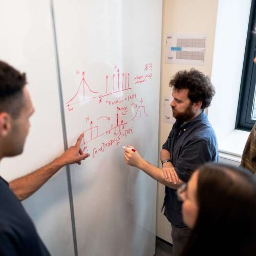 Expertos en datos abordan su análisis sobre una pizarra