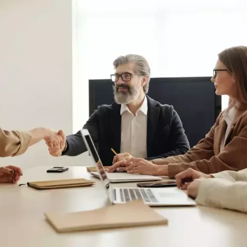Un reclutador estrecha la mano de un candidato tras una entrevista de trabajo.